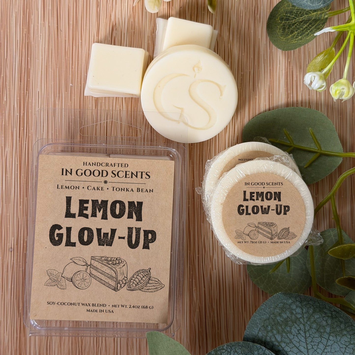Handcrafted wax melts with 'Lemon Glow-Up' packaging on a wooden surface with greenery.