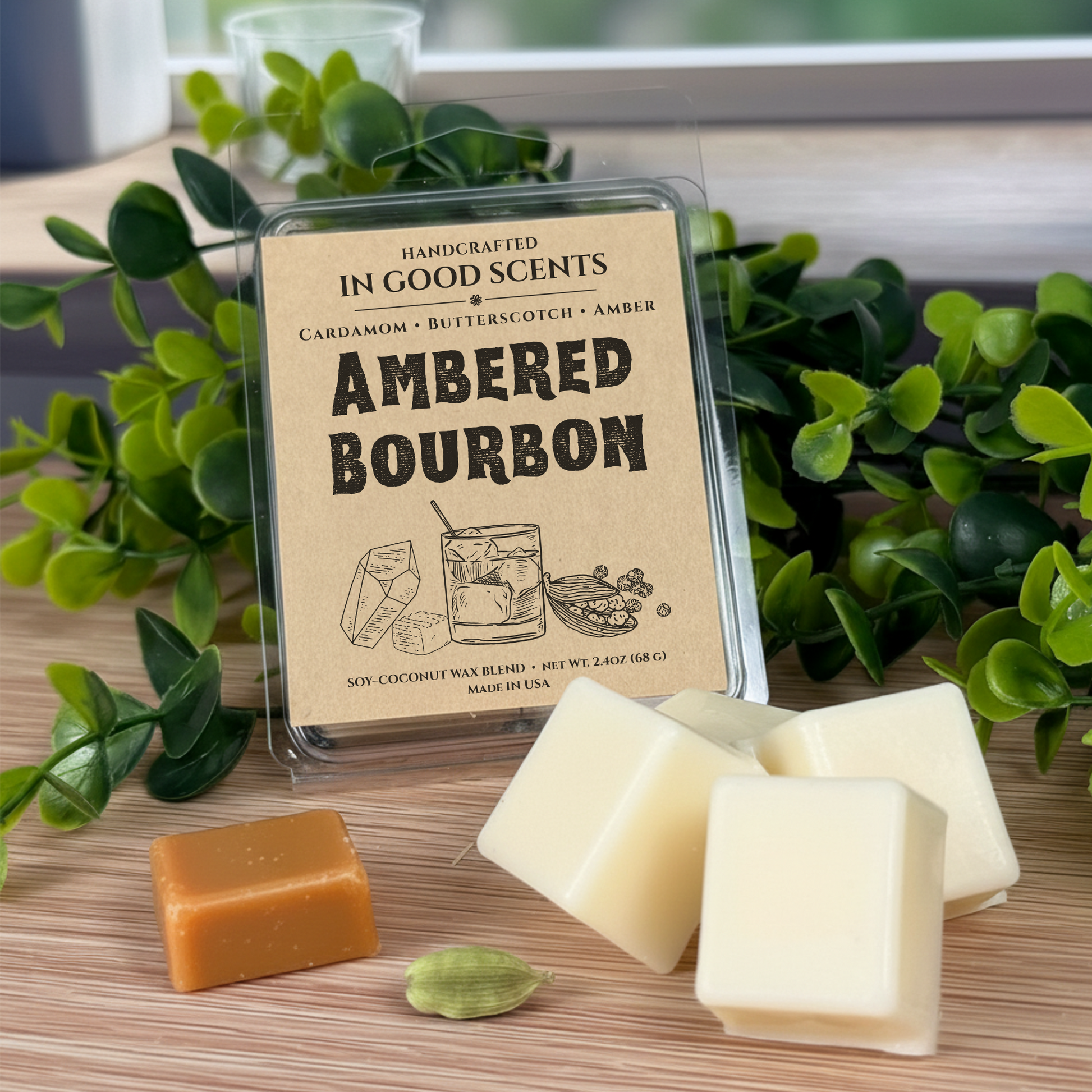 Handcrafted wax melts with 'Ambered Bourbon' packaging on a wooden surface with greenery.