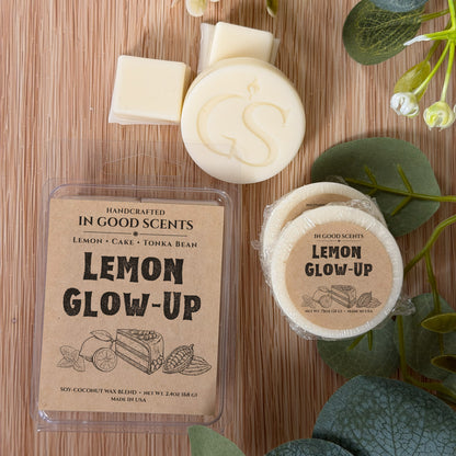 Handcrafted wax melts with 'Lemon Glow-Up' packaging on a wooden surface with greenery.