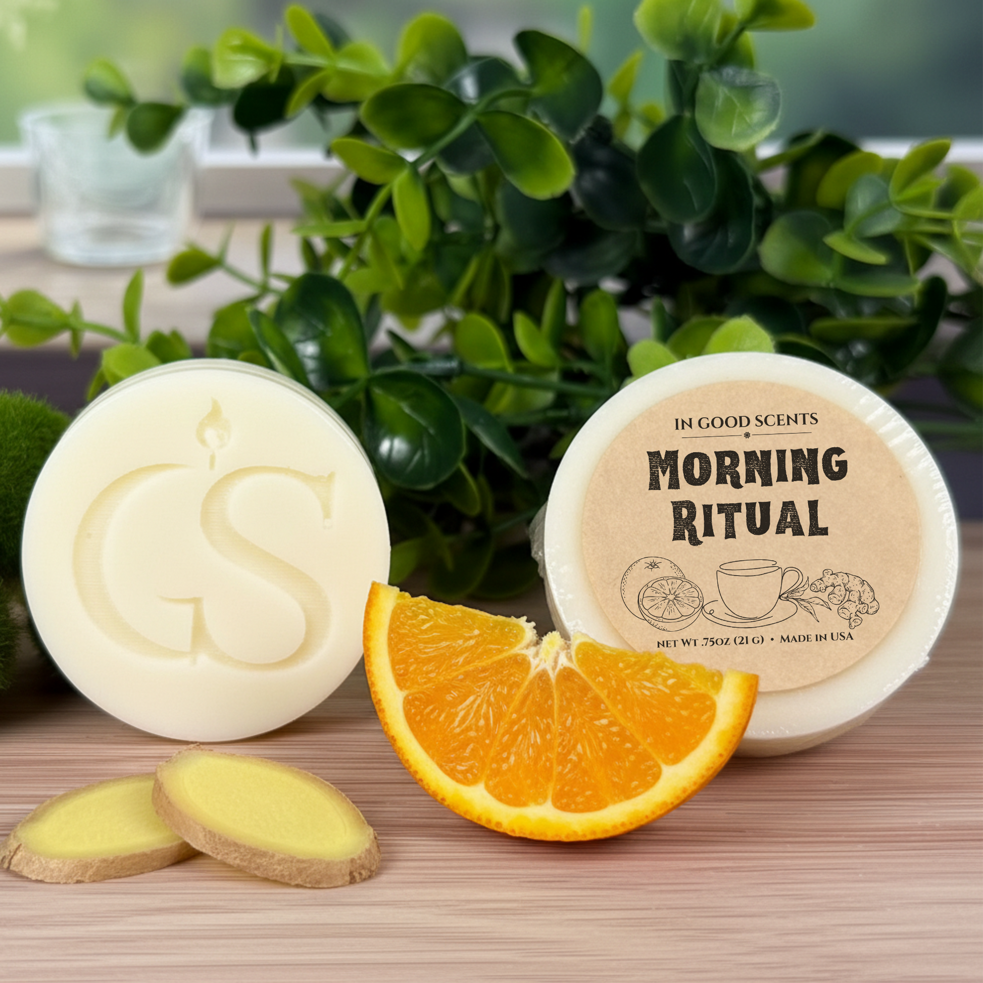In Good Scents Morning Ritual 0.75oz wax melt tart with GS logo, wrapped tart label shown with orange slice and ginger on wood surface.