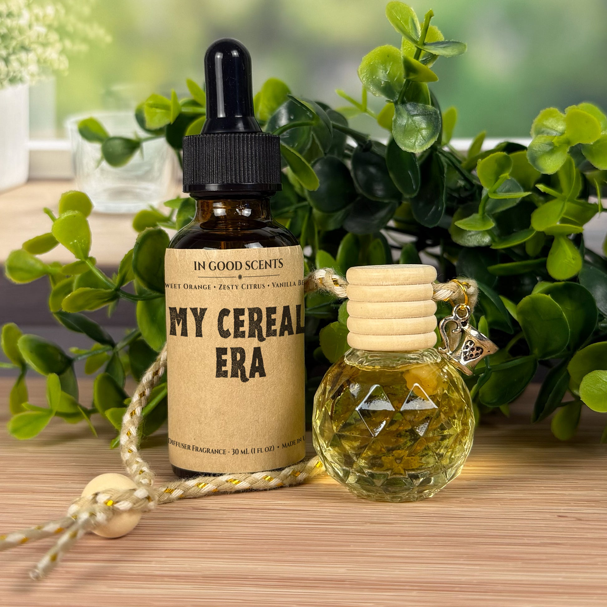 Two bottles of fragrance with decorative elements on a wooden surface with greenery in the background.