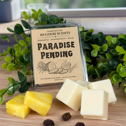 Paradise Pending wax melts clamshell by In Good Scents with pineapple pieces and creamy wax cubes on wood surface.