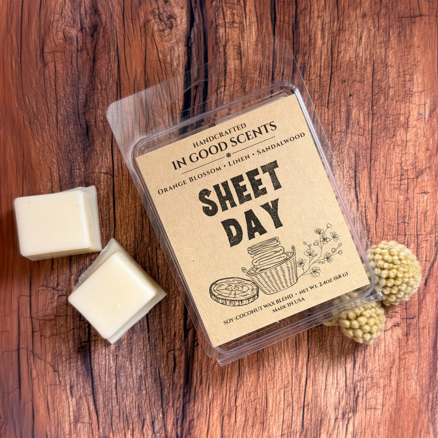 Wax melt packaging labeled 'Sheet Day' on a wooden surface with wax melts and decorative elements.
