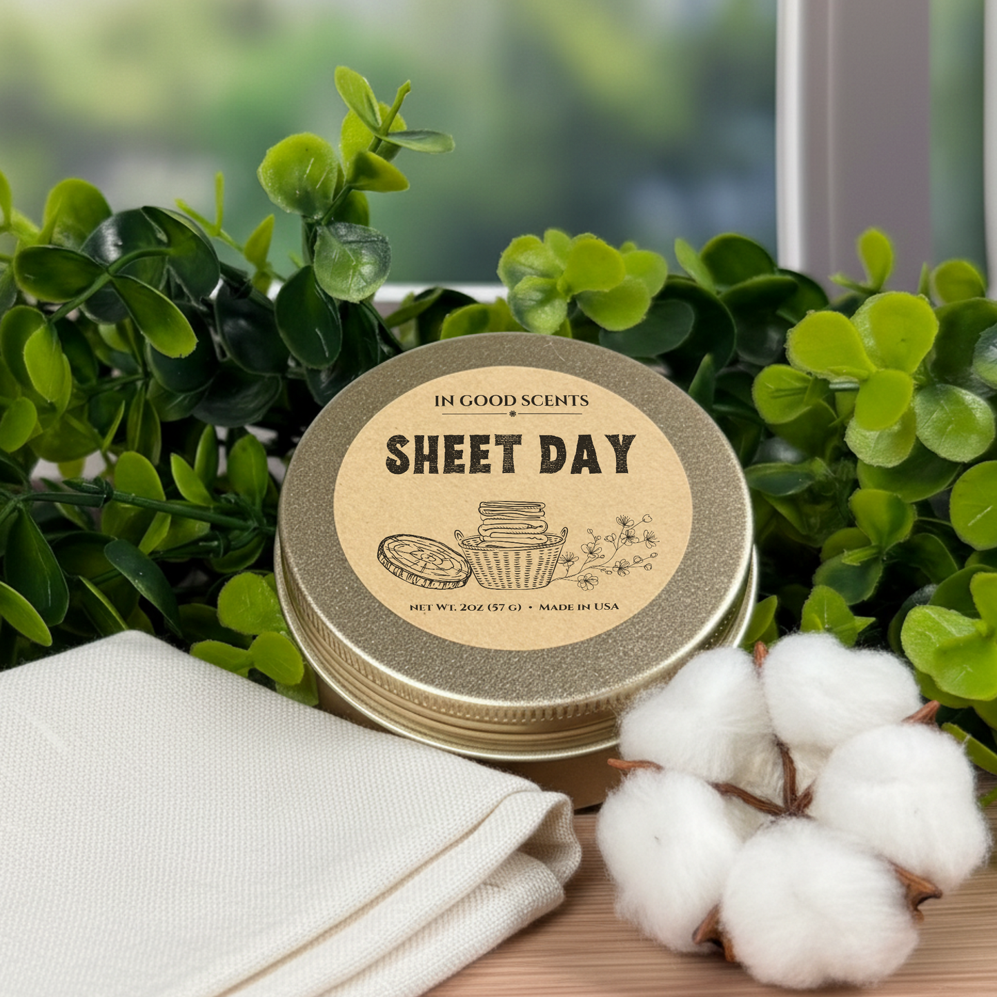 Sheet Day 2oz travel tin candle with kraft lid label, styled with folded linen and cotton stems.